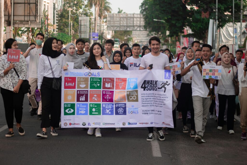 Young adults participating in a march to promote awareness of the UN Sustainable Development Goals.