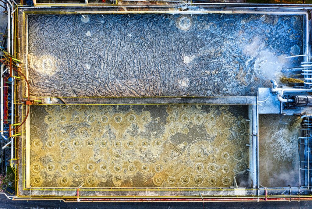 Aerial shot of an industrial water treatment plant with visible aeration tanks and machinery in Indonesia.