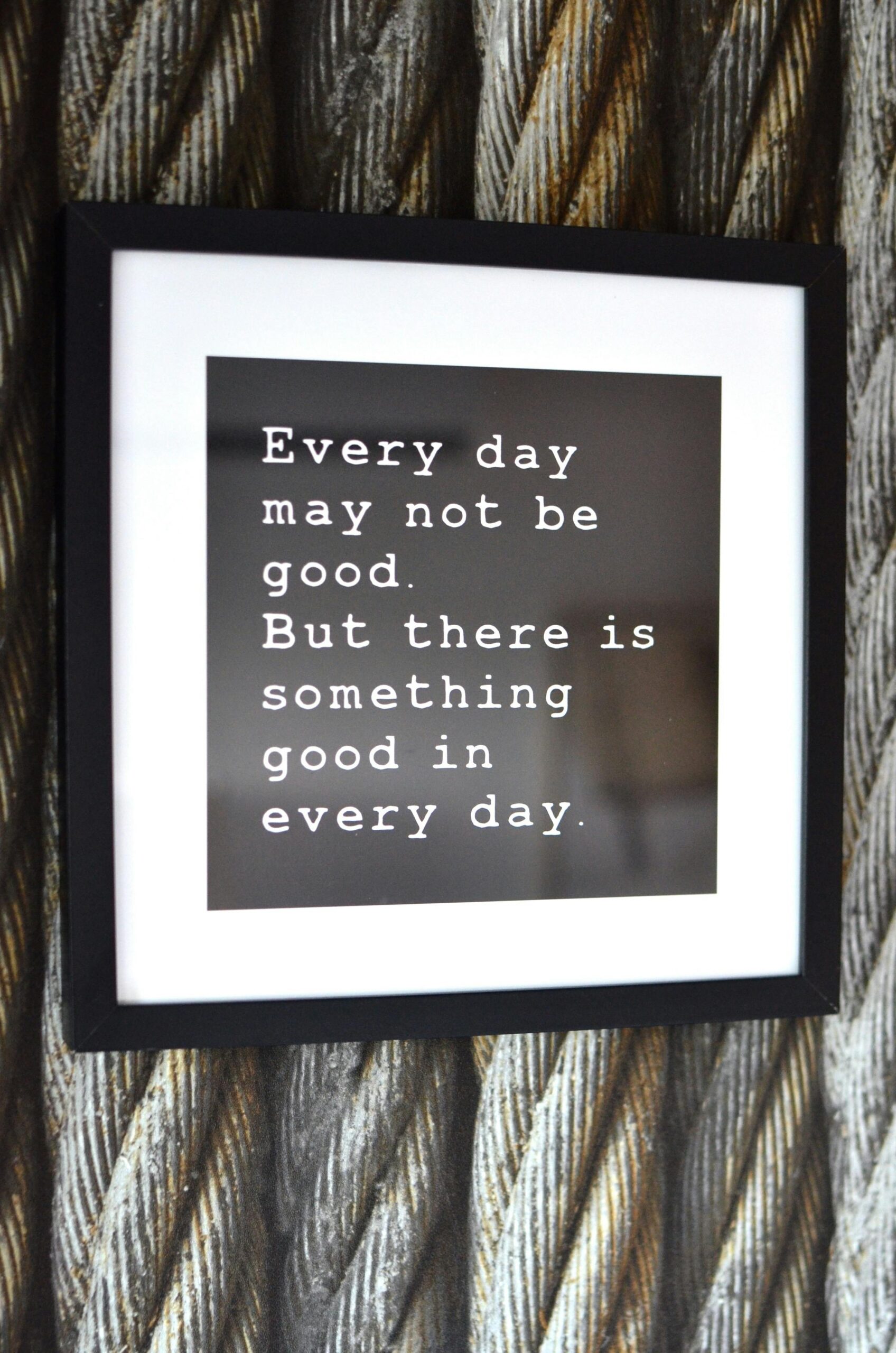 Framed motivational quote on a rope-textured background, emphasizing daily positivity.